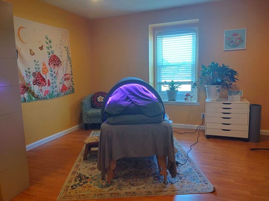 The studio with the Sunlighten Solo infrared sauna pod glowing purple